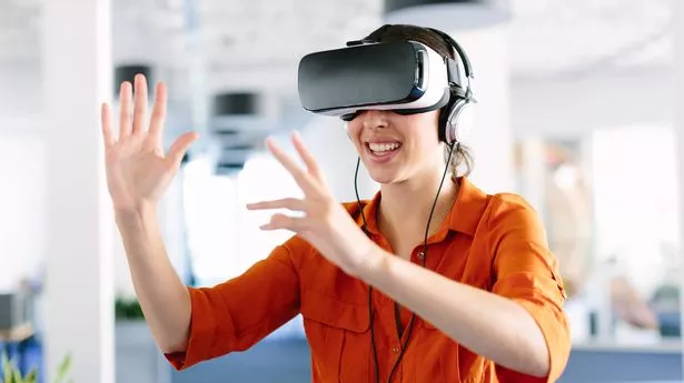 Молодая женщина в очках виртуальной реальности и жестикулирует в офисе