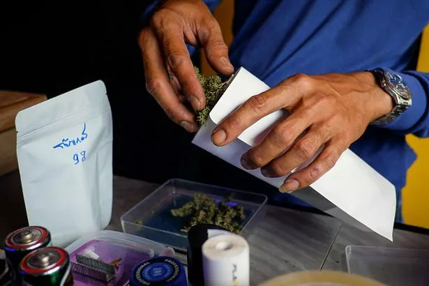 Продавец упаковывает шишки марихуаны в аптеке по продаже каннабиса в Сичоне.