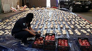Сотрудник таможни Саудовской Аравии открывает импортированные гранаты, поскольку таможня предотвратила попытку контрабанды более 5 миллионов таблеток каптагона в 2021 году.